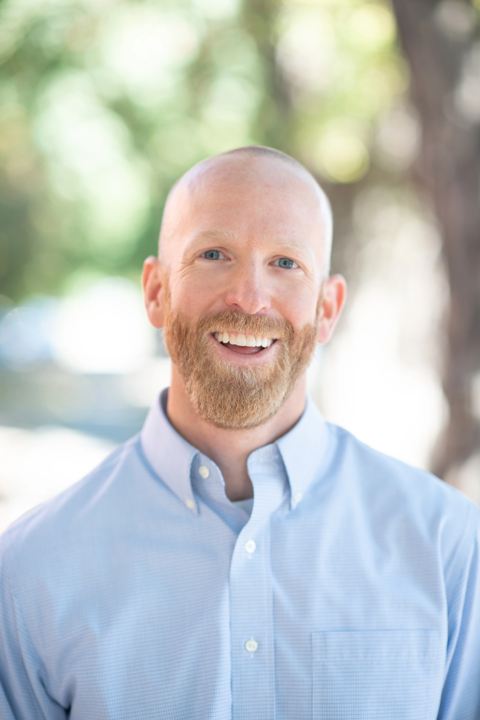 Smiling man in blue shirt outdoors